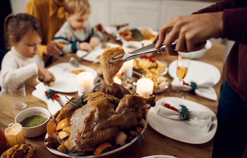 closeup-man-serving-turkey-meat-family-meal-thanksgiving